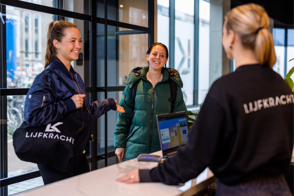 Een receptioniste die 2 klanten begroet